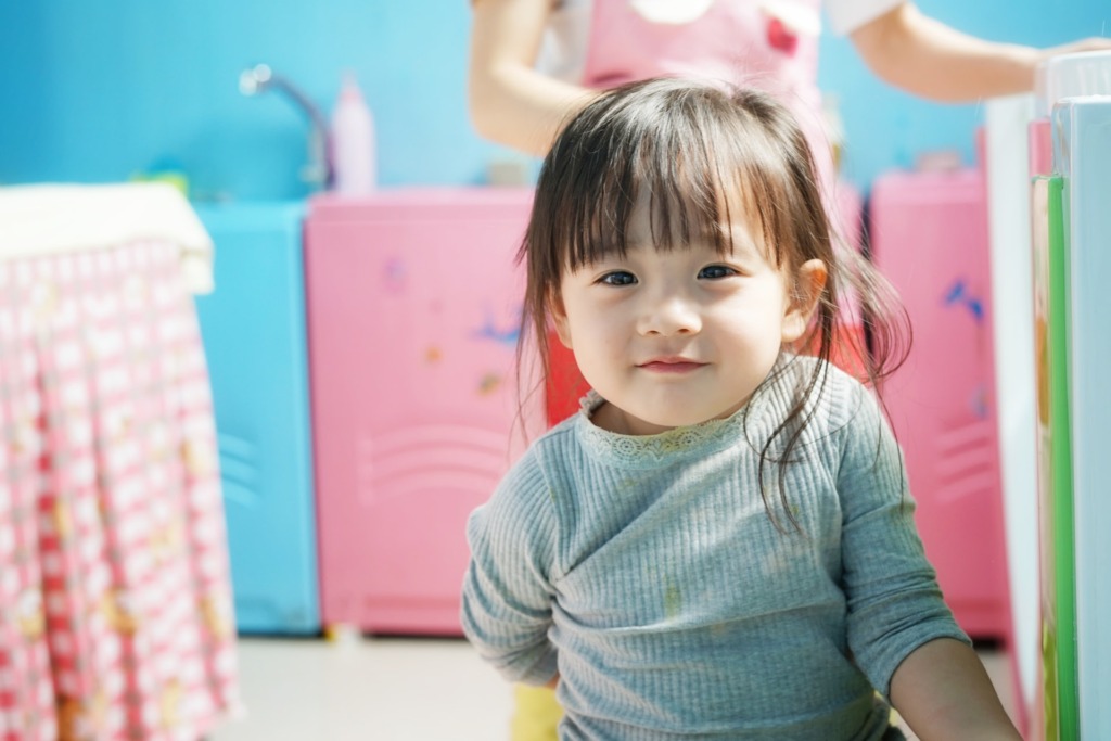 カラフルな部屋でほほえむ小さな女の子