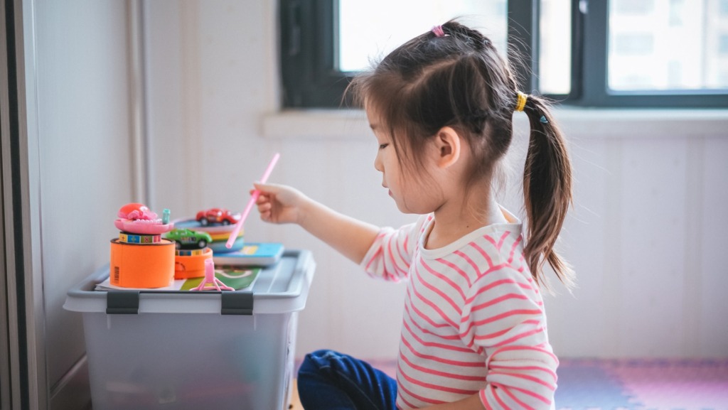 机で色鉛筆を持って絵を描く女の子。家庭学習のイメージ